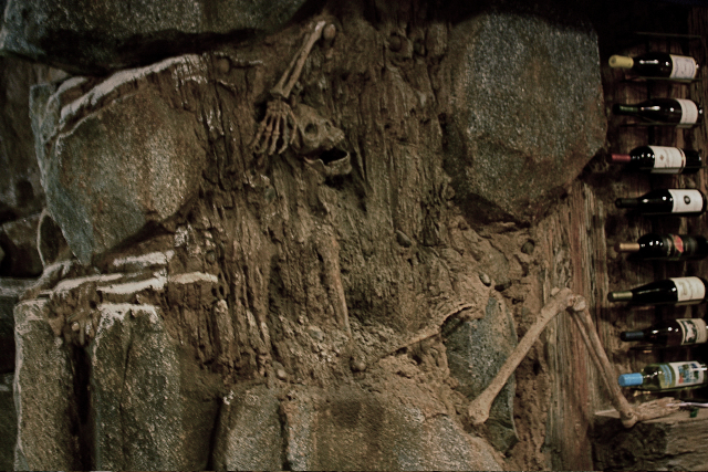 Skeleton embedded in a rock wall decor, adding ambiance to a Southern California Bar