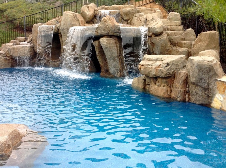 Pool with multiple cascading waterfalls, creating a picturesque and serene atmosphere ideal for relaxation and enjoyment.
