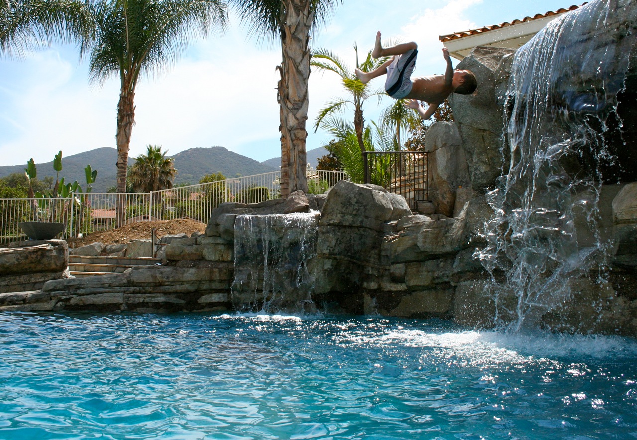 Pool with a custom waterfall, creating an environment to relax in.