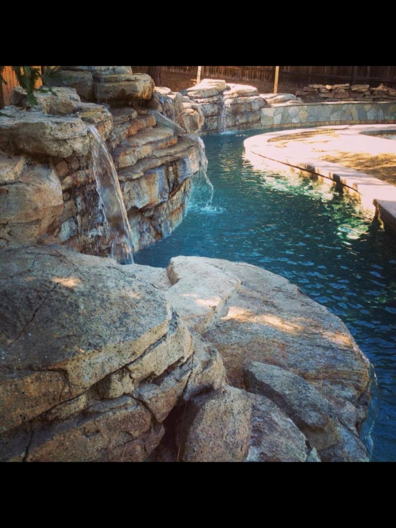 Pool with a custom waterfall, creating an environment to relax in.